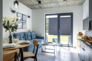 a kitchen and living room with a blue couch and a table at LILIOWA 15 in Dębki