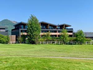 duży budynek z zielonym polem przed nim w obiekcie Teehouse Golf Apartment w mieście Czeladna