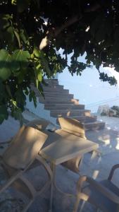 a group of chairs sitting on a beach with stairs at Condo Rooms in Sarandë