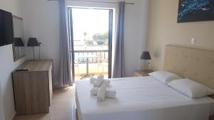 a bedroom with a bed with two teddy bears on it at Hotel Prassino Nissi in Moraitika +15 photos