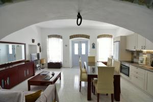 a kitchen and living room with a table and chairs at Arco I/ Downtown Rustic Apartment/4 min from port in Hydra
