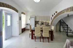 a kitchen and dining room with a table and chairs at Arco I/ Downtown Rustic Apartment/4 min from port in Hydra