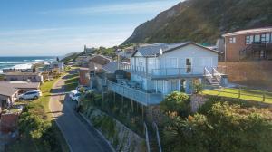 a house on a hill next to the ocean at No 52 Eersterivier Rd Tsitsikamma in Eersterivierstrand