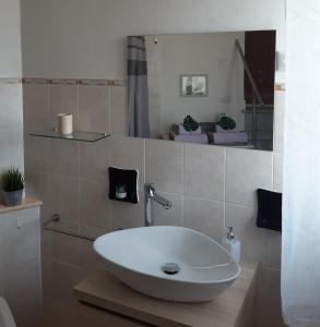 een badkamer met een witte wastafel en een spiegel bij Sa Calla Manna in Portoscuso