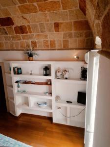 a room with white shelves and a brick wall at Brezza Marina in Polignano a Mare +38 photos