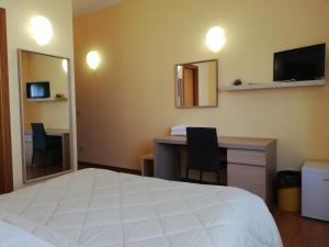 - une chambre avec un lit, un bureau et un miroir dans l'établissement Albergo Roma, à Lanciano