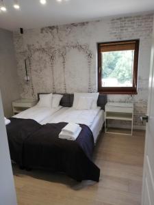 a bedroom with two beds and a window at Apartament Latarnik- Yellow in Gąski