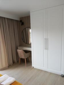 a bedroom with a white closet and a desk at Apartament Latarnik- Yellow in Gąski