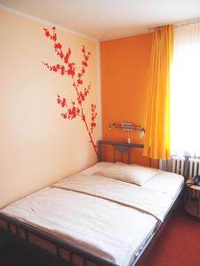 a bedroom with a bed with a plant on the wall at Hotel Am Römerhof in Bonn