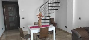 a dining room with a table with chairs and a staircase at Apartamento Numi II in L'Ametlla de Mar