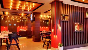 a restaurant with tables and chairs and lights at Bharalu Residency in Guwahati