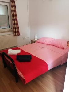 a bedroom with a large bed with a red blanket at Holiday House Barbara in Medulin