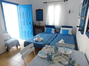 Un dormitorio con una cama azul y una mesa en Yacht Front Studio - Back Yard - No 8, en Ios Chora