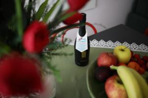 利多迪迪耶索洛的住宿－Residence Mariavittoria，一瓶葡萄酒,坐在一盘水果旁边