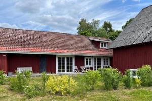 a red house with a red roof at Brogård - gårdlejlighed in Agunnaryd
