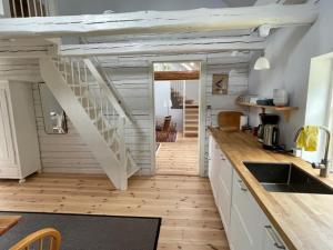 a kitchen with a staircase in the middle of a room at Brogård - gårdlejlighed in Agunnaryd