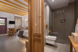 łazienka z toaletą i łóżko w pokoju w obiekcie Kaminos Boutique Hotel w mieście Simi