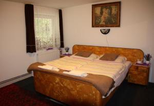 a large bed in a bedroom with a window at Penzion Valovi in Merklín