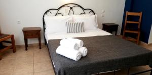 a bedroom with a large bed with towels on it at Rigas Apartments in Skiathos Town