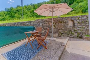 una mesa y una silla con sombrilla junto a la piscina en Perfektes Appartement für Erholung in der Wachau!!, en Spitz