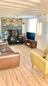a living room with a couch and a fireplace at Snowdonia Retreat in Trefriw