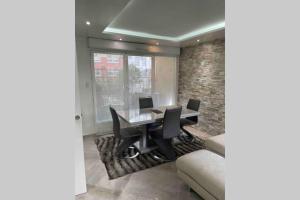 a dining room with a table and chairs and a brick wall at Appartement proche Paris et Disney land. in Rosny-sous-Bois