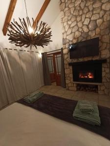 a living room with a stone fireplace and a blanket at Kleinzee Oceanfront Guesthouse in Gansbaai