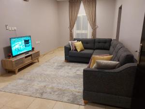 sala de estar con sofá y TV en نزل الشرقي, en Abha