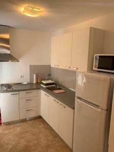 cocina con armarios blancos y nevera blanca en Apartment Matteotti 199 en Rovinj