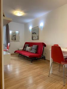 a living room with a red couch and a table at Apartment Matteotti 199 in Rovinj