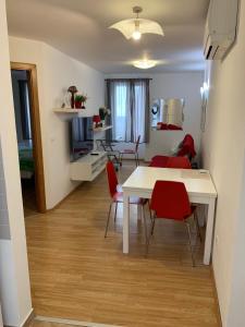 sala de estar con mesa blanca y sillas rojas en Apartment Matteotti 199, en Rovinj