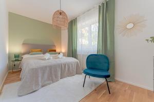 a bedroom with a bed and a blue chair at Garden.Lodge Spitz in der Wachau in Spitz