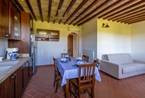 a kitchen and dining room with a table and a couch at Agriturismo Corte Dainelli in Montaione