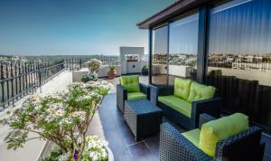 a balcony with couches and chairs on a building at Nadine Hotel Suites in Amman