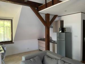 un soggiorno con divano e frigorifero di Apartamenty, domki, wędkowanie a Barlinek