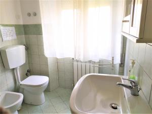 a white bathroom with a toilet and a sink at B&B Casa Valentina a Linguaglossa in Linguaglossa