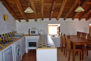 Una cocina con encimera y mesa con sillas. en Fincaretama Farmhouse Apartment Ronda, en Ronda