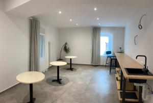 a kitchen with tables and stools in a room at Castle Rhythm in Arco