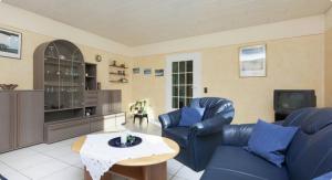 a living room with a blue couch and a table at Landhaus Dorothee in Meisburg