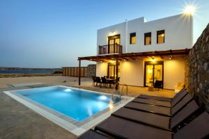 a villa with a swimming pool in front of a house at Cato Agro 5, Seafront Villa with Private Pool in Karpathos