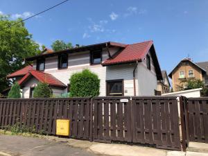 a house with a wooden fence in front of it at Apartament 4 plus 1 w Karkonoszach in Jelenia Góra