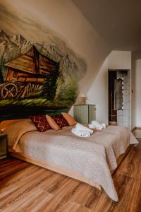 a bedroom with a large bed with a painting on the wall at Apartament Gazdowski in Bukowina Tatrzańska