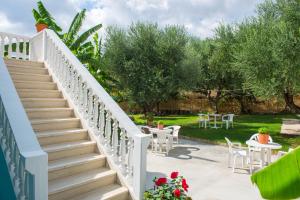a staircase leading to a garden with tables and chairs at Cleopatra Apartments in Laganas +14 photos
