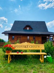 un banco de madera frente a una cabaña de madera en Liptovské Chaty, en Liptovský Mikuláš