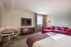 Pokój hotelowy z łóżkiem, kanapą i stołem w obiekcie Holiday Inn AlSeeb Muscat, an IHG Hotel w Maskacie