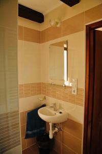 a bathroom with a sink and a mirror at Viktor Vendégház és Apartmanház in Baktalórántháza +27 photos