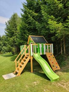 um parque infantil com um escorrega e uma estrutura de jogos em Holiday Home Prdelanca em Luče
