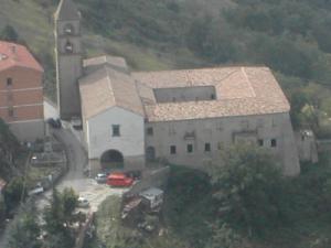 un gran edificio con una torre y una iglesia en Ercole, en Pietrapertosa
