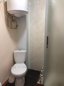 a small bathroom with a toilet and a light at Grand Victoria Hotel in Kyrylivka