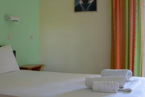 a bedroom with a bed with towels on it at Rose Garden in Melíkia